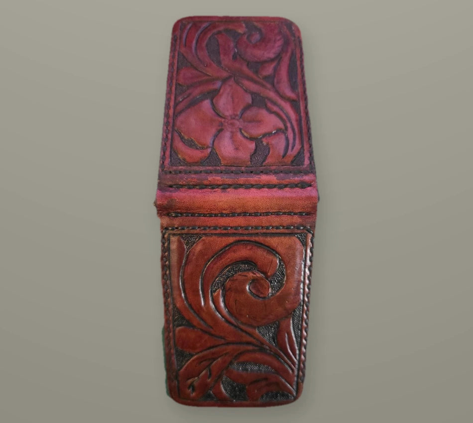 Two connected red floral-tooled leather wallet panels against a muted slate background